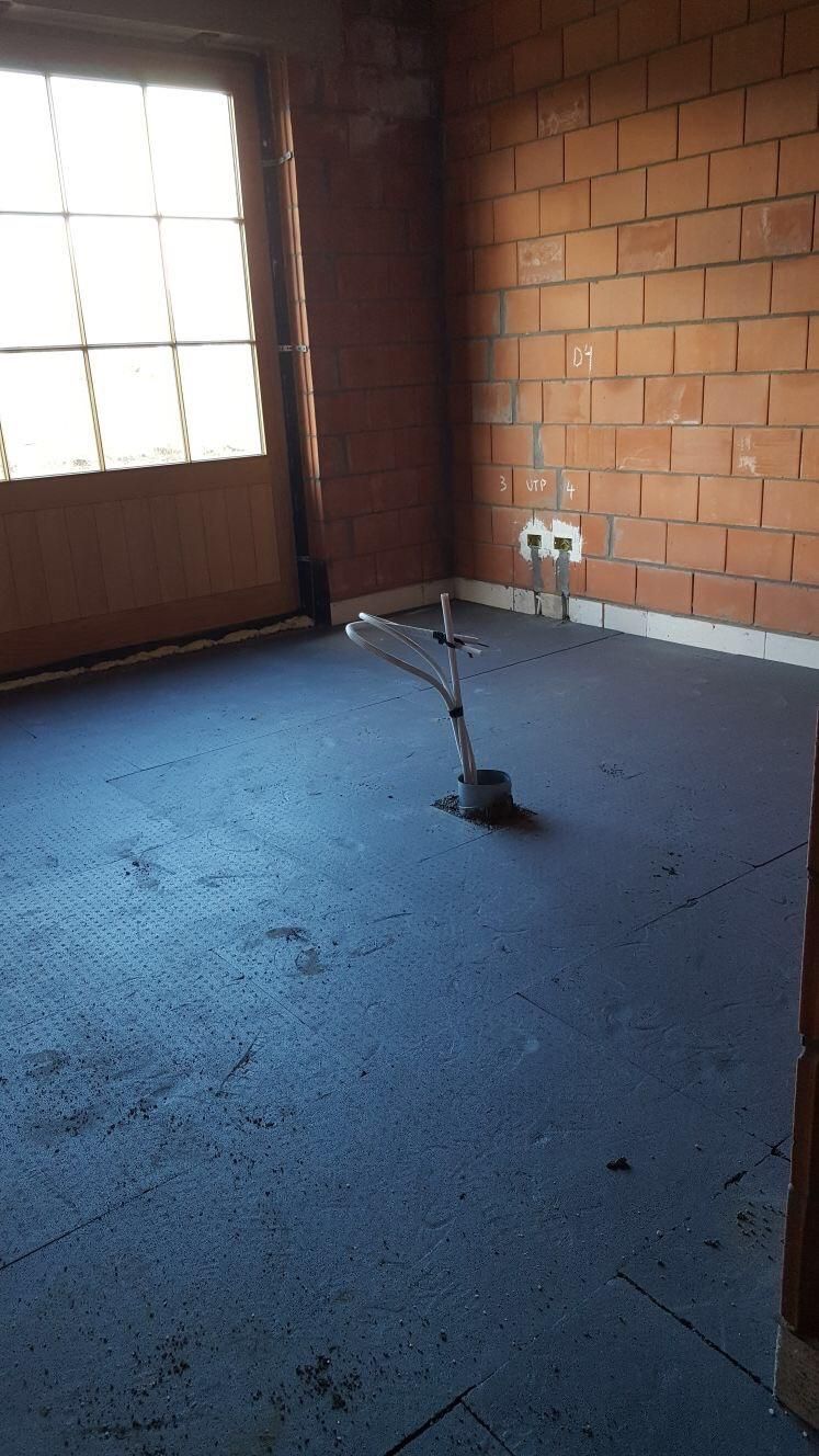 Nieuwbouw kamervloer met isolatieplaten en bakstenen muren, optimalisatie voor thermische prestaties en energie-efficiëntie.