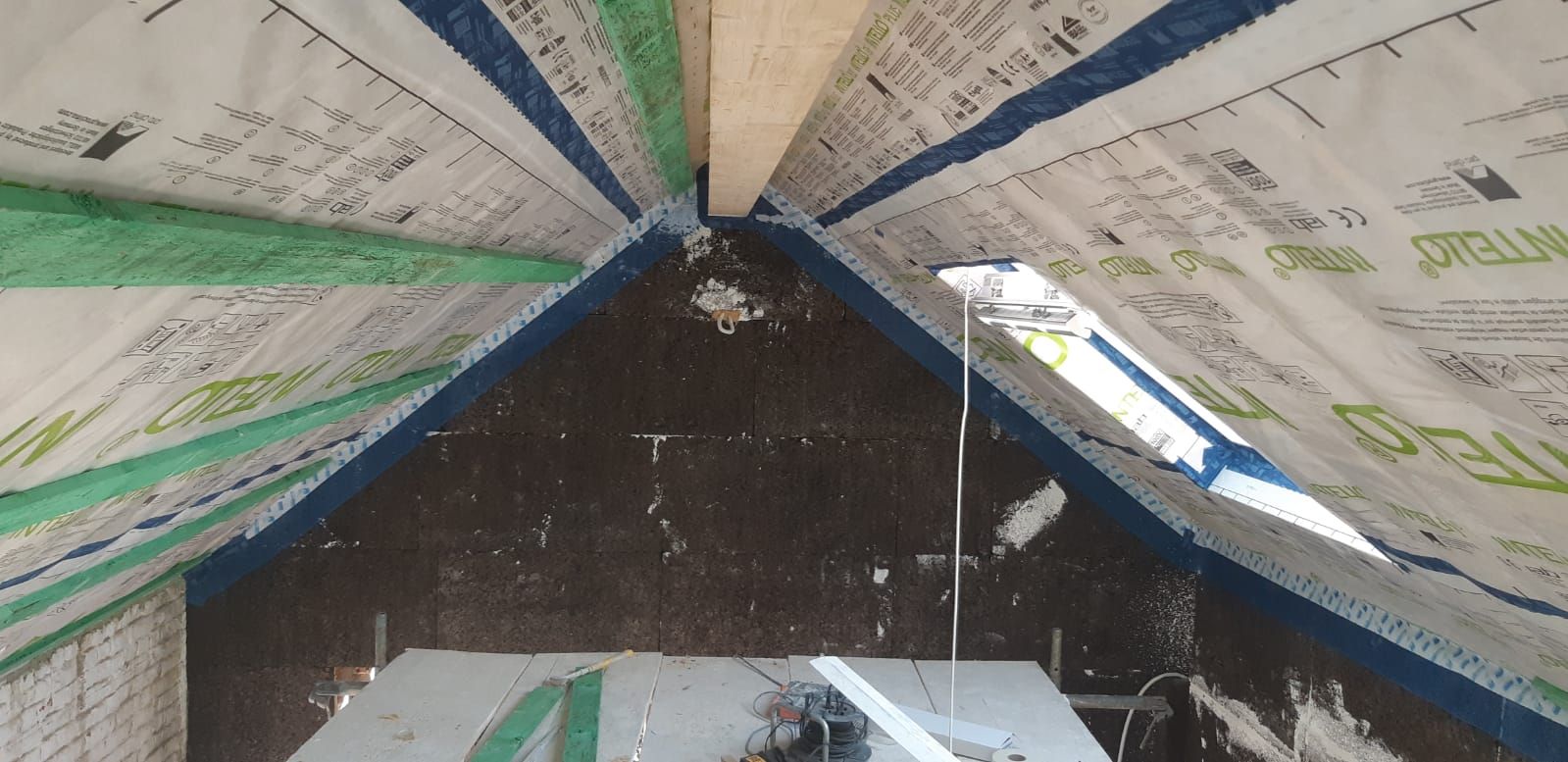 Dakisolatie in een schuin dak, gebruik van dampremmende folies voor optimale energie-efficiëntie en thermisch comfort.