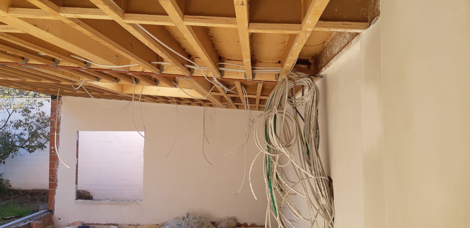 Houten plafondconstructie met bekabeling, voorbereidingen voor isolatie en energiezuinige renovatie van binnenruimte.